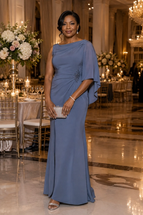 A woman wears a floor-length blue-gray draped gown with a jeweled waist detail, clutch, drop earrings, bracelet, and metallic sandals.