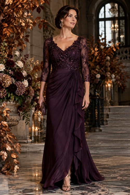 Woman wearing a floor-length plum gown with sheer lace sleeves, an embellished bodice, a draped ruffled skirt, and metallic sandals.