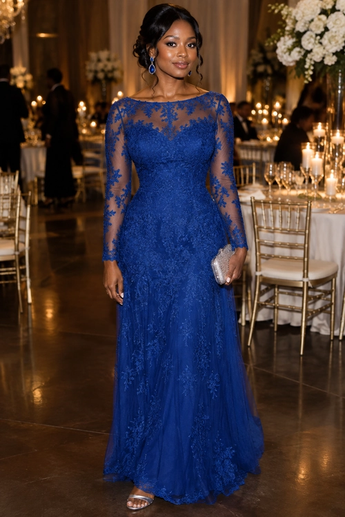 Woman wearing a royal blue floor-length lace gown with sheer long sleeves, silver clutch, and metallic sandals.