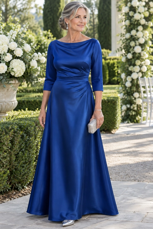 Royal Blue Satin Formal Gown Woman wearing a royal blue satin floor-length gown with a ruched waist, silver clutch, and metallic pointed shoes.