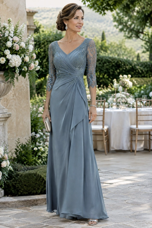 Slate Blue Lace-Sleeve Evening Gown Woman wearing a slate blue floor-length gown with lace three-quarter sleeves, a V-neckline, draped ruching, and a small clutch.