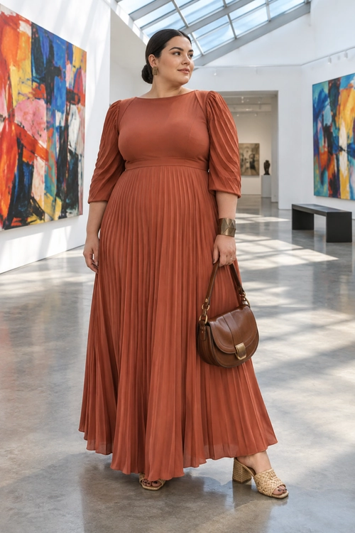 Terracotta Pleated Dress Outfit A woman wears a terracotta pleated maxi dress with ruched sleeves, a brown shoulder bag, and woven block-heel sandals in an art gallery.